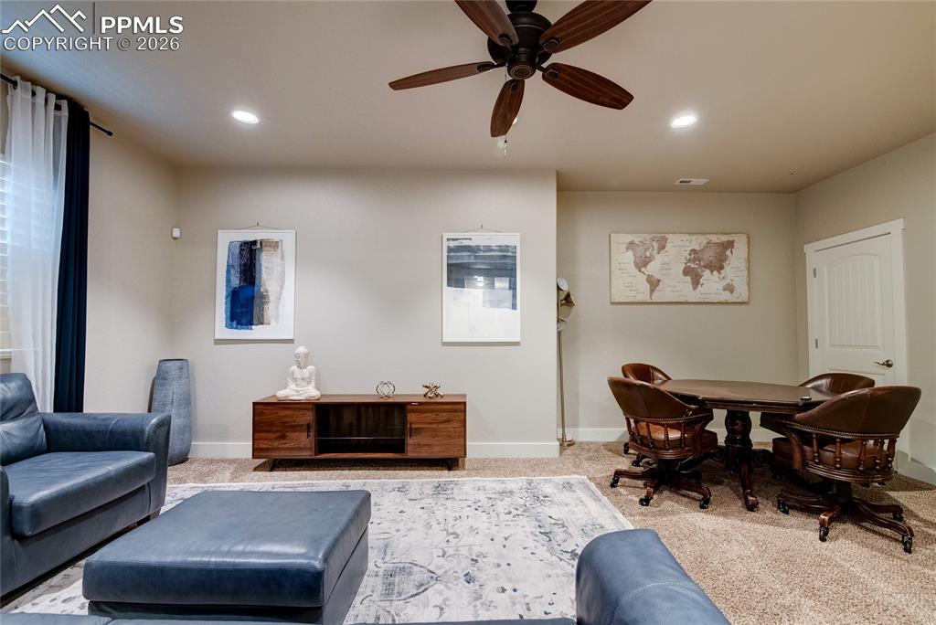 Living room featuring carpet flooring, a ceiling fan, and recessed lighting