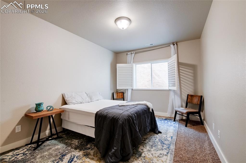 Bedroom featuring baseboards and dark colored carpet