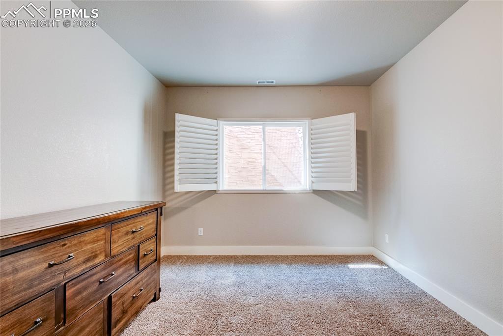 Unfurnished bedroom featuring light colored carpet and baseboards
