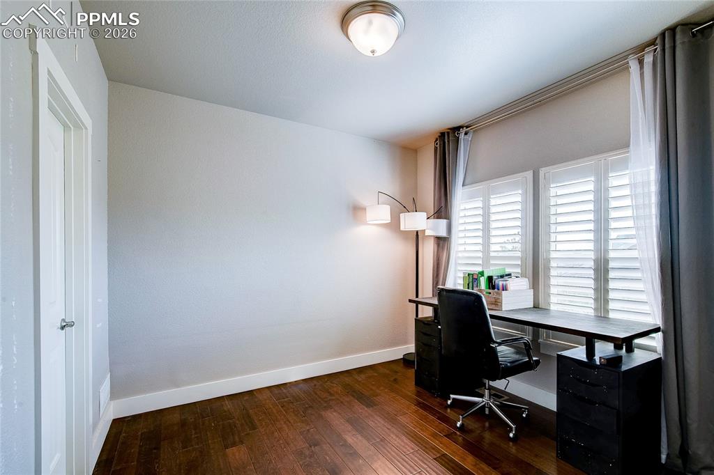 Office featuring dark wood-type flooring and baseboards