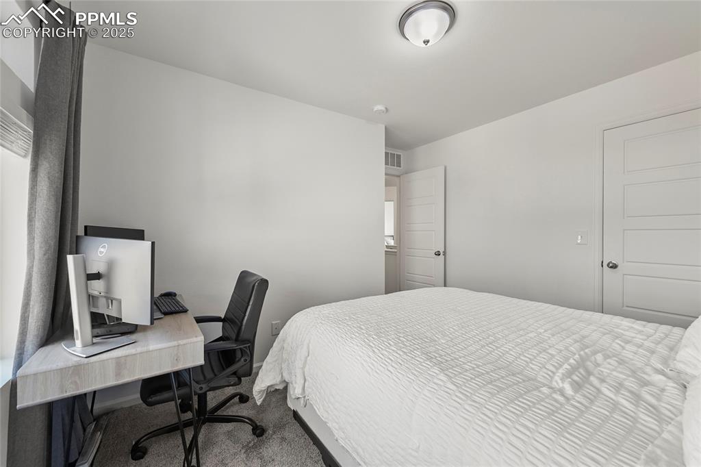 Bedroom featuring carpet and an office area