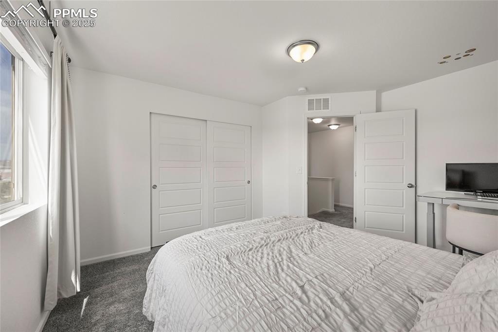 Bedroom with dark carpet and a closet