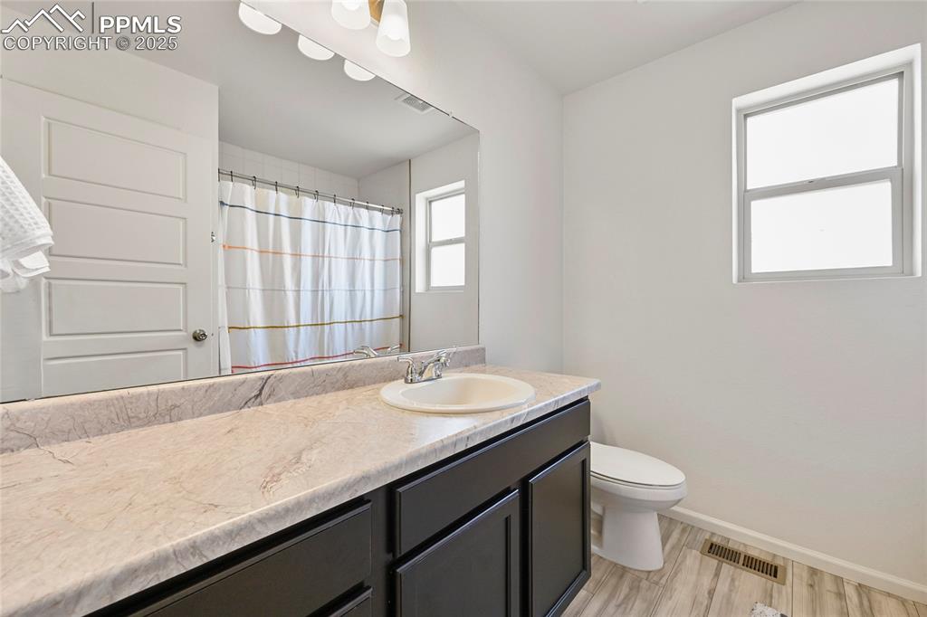 Bathroom with vanity, light wood-style floors, and curtained shower
