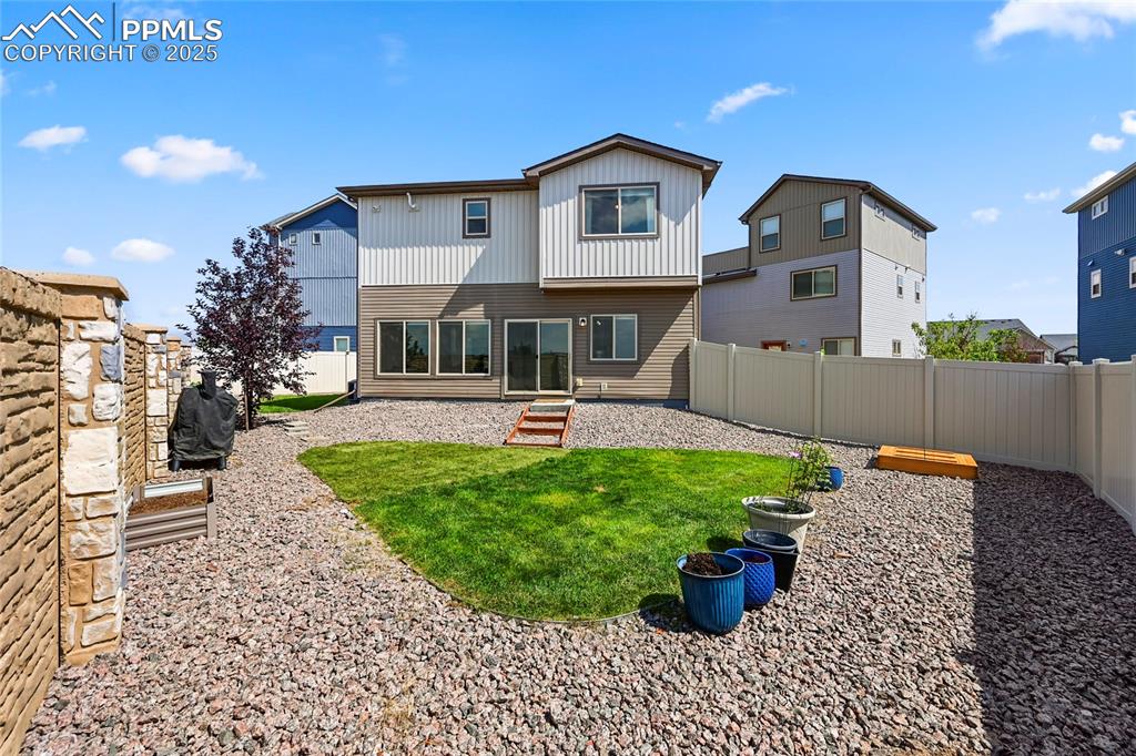 Back of property with a patio, a fenced backyard, and entry steps