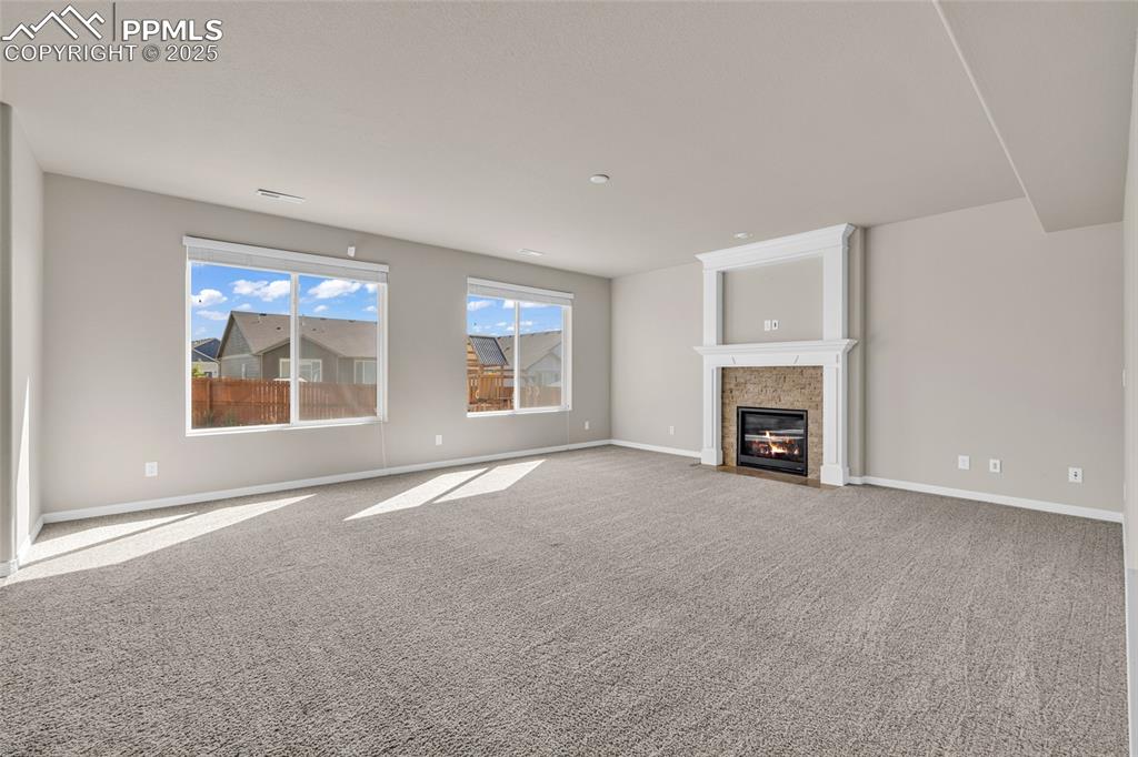 Unfurnished living room with carpet and a fireplace