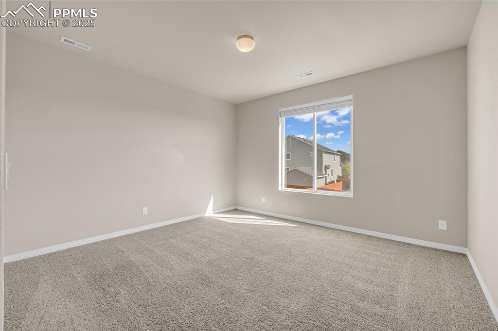 Empty room featuring light colored carpet and baseboards