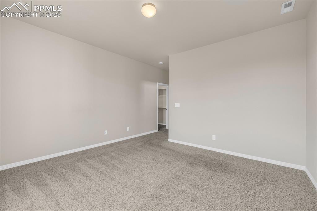 Carpeted empty room featuring baseboards