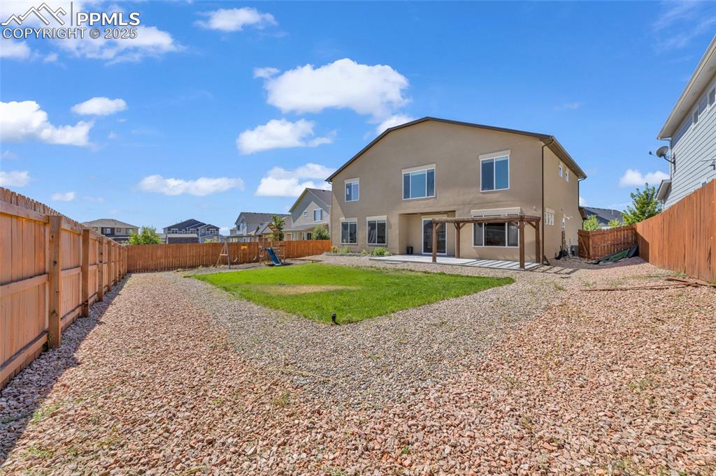 Rear view of house with a patio, a fenced backyard, and stucco siding