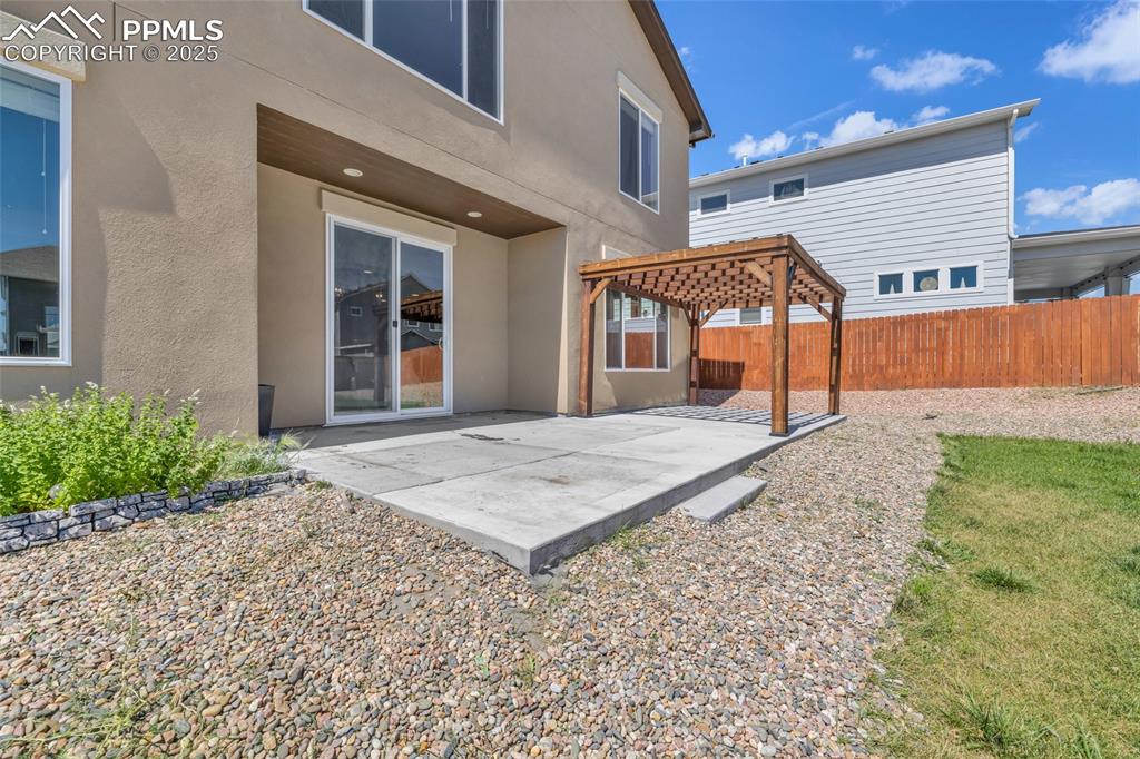 Back of house featuring stucco siding, a patio area, and a pergola