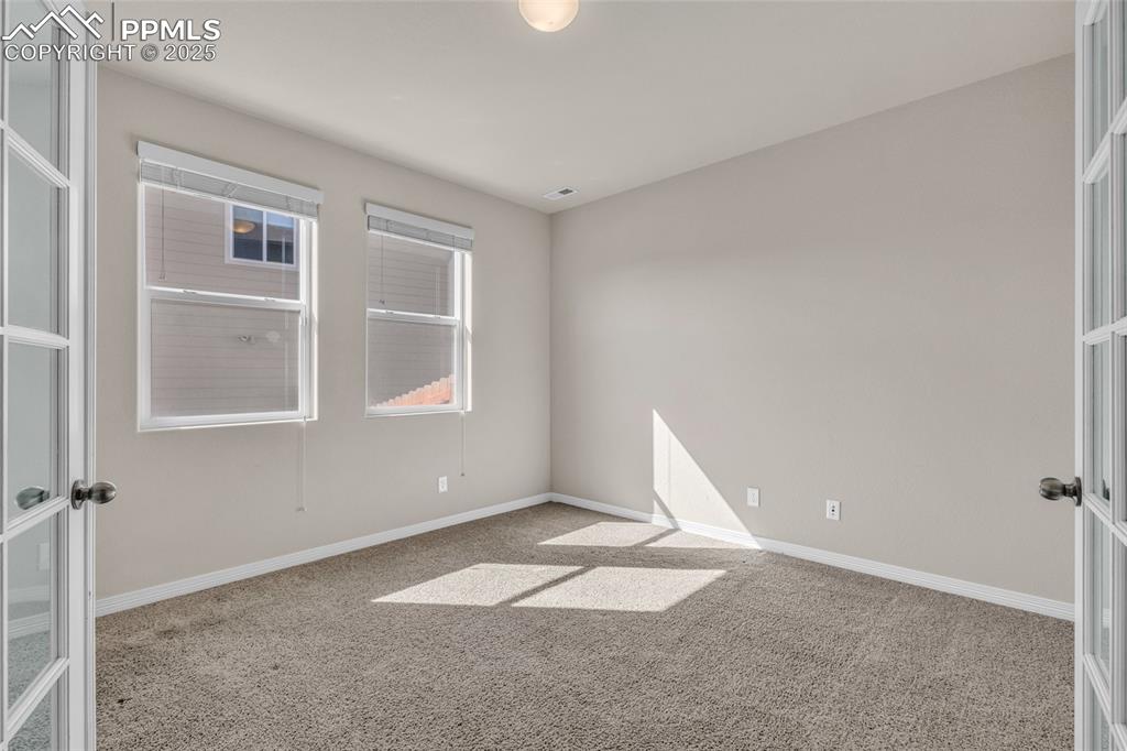 Unfurnished room featuring light colored carpet and french doors