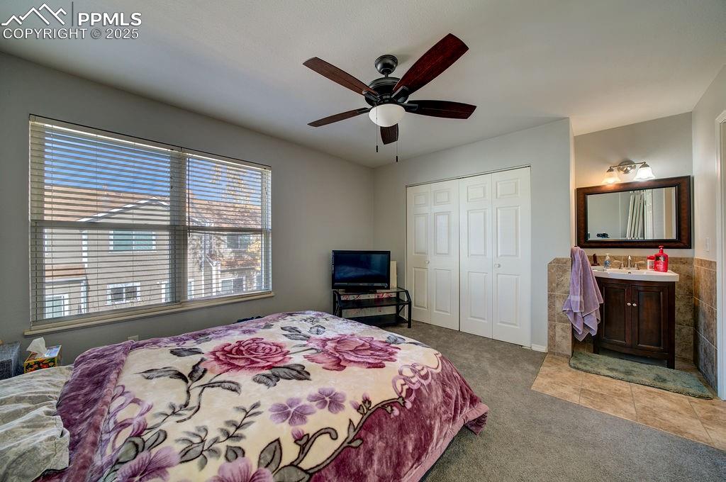 Upper level Bedroom #2 has an adjoining Bathroom with vanity, framed mirror, and tub/shower.