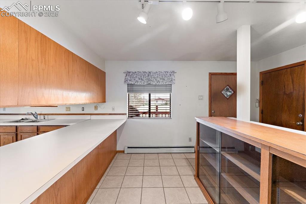 Kitchen with light tile patterned flooring and wooden counters
