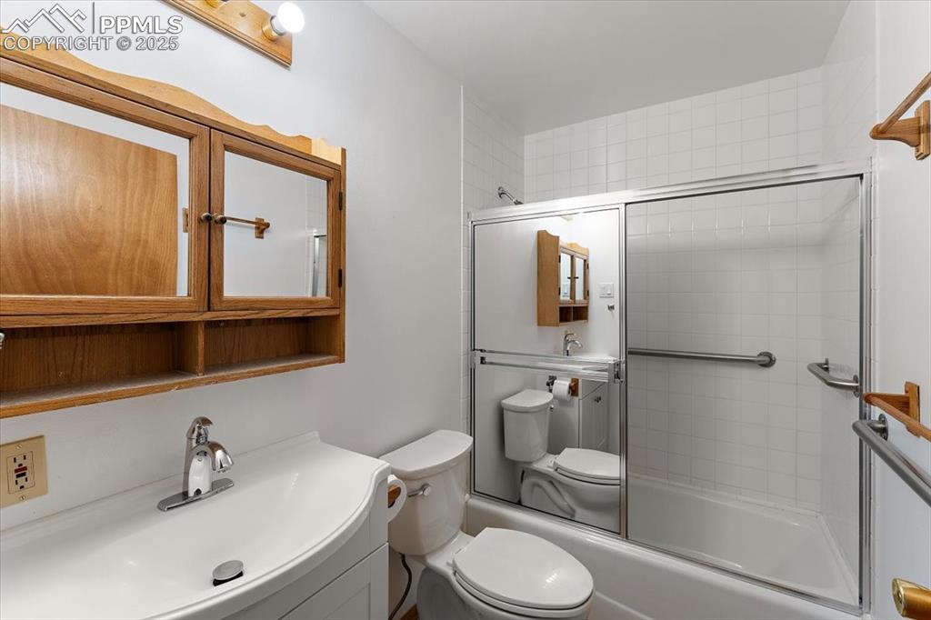 Full bathroom featuring enclosed tub / shower combo and vanity