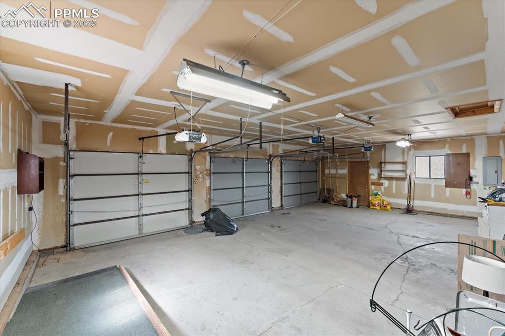 Garage with electric panel and a garage door opener