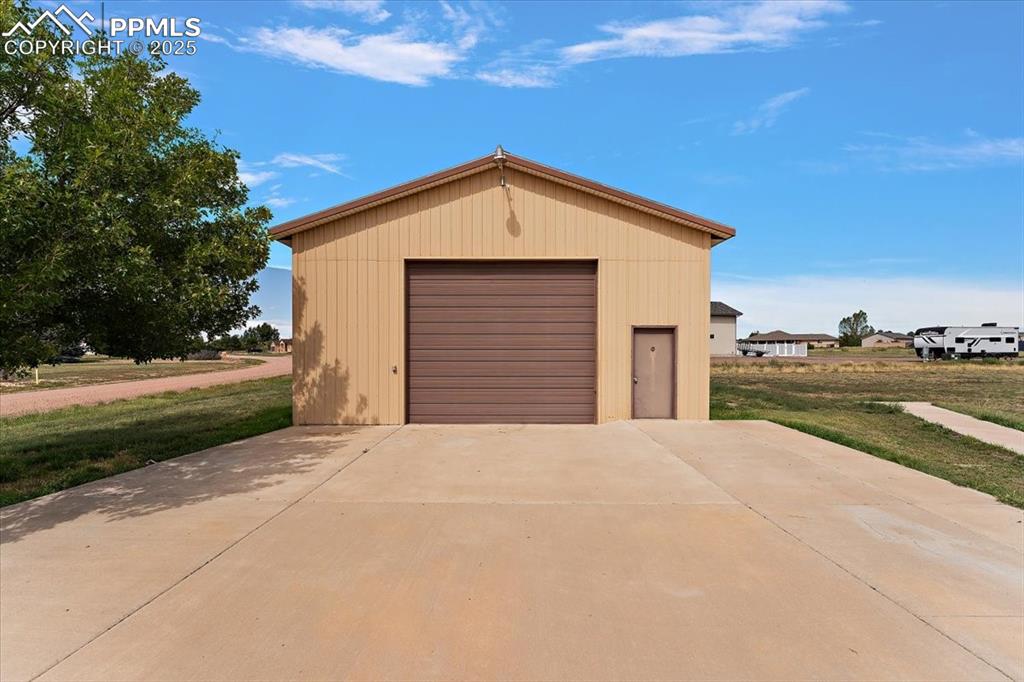 Detached garage featuring concrete driveway