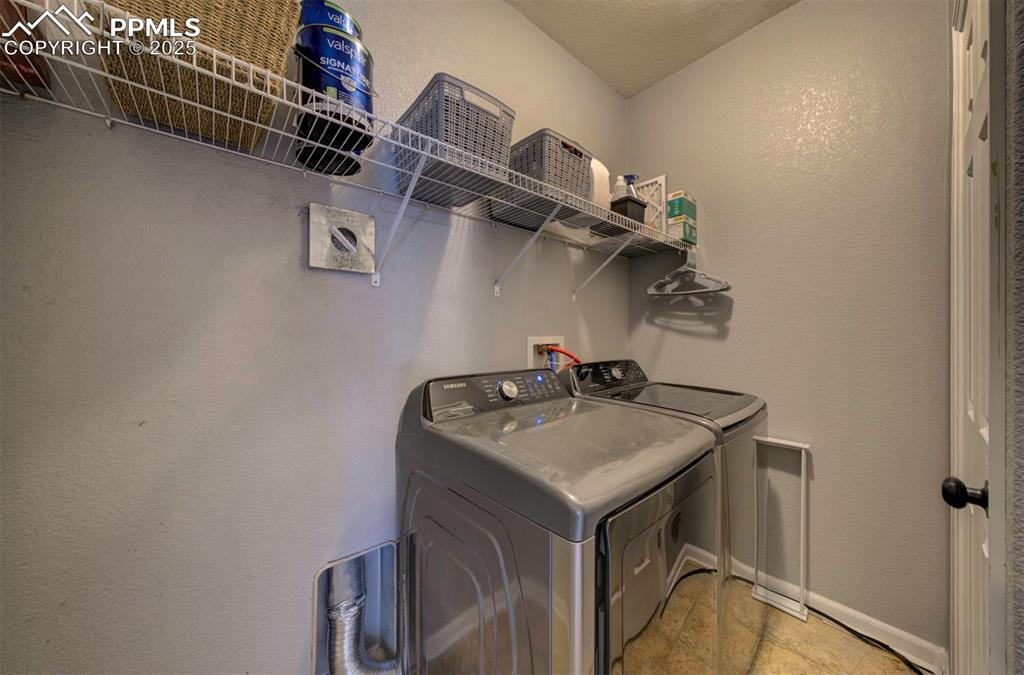 Washroom with a textured wall and washing machine and clothes dryer