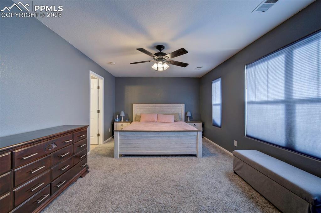 Bedroom with light carpet and a ceiling fan