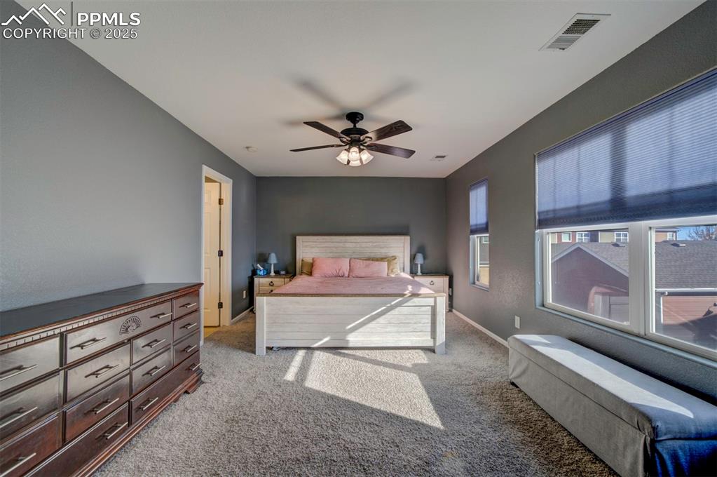 Bedroom with light colored carpet and ceiling fan