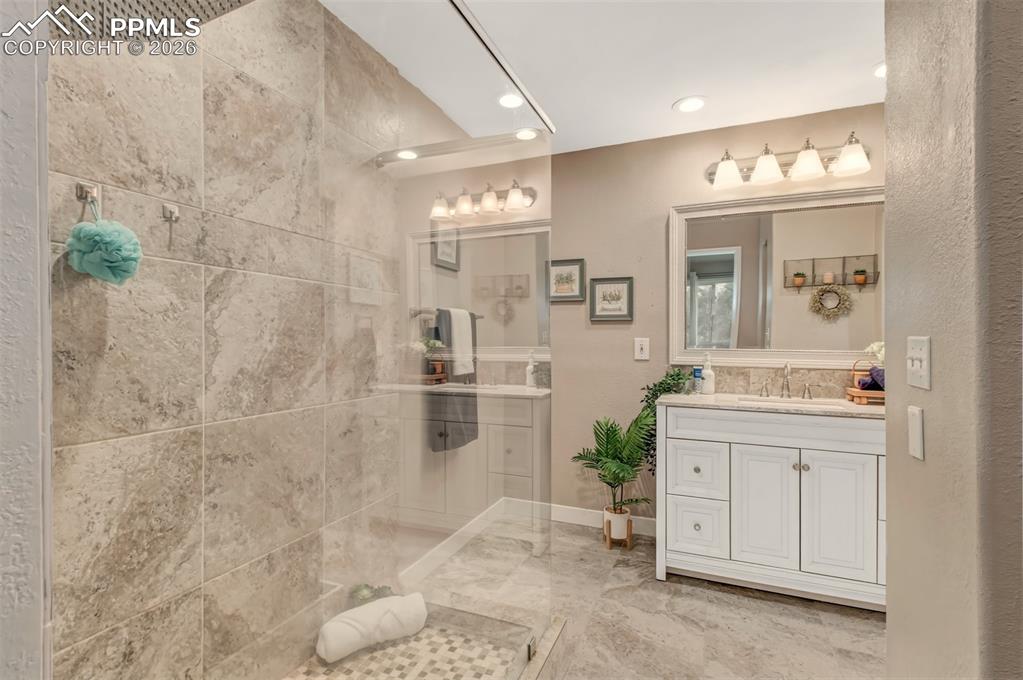 Master bathroom featuring a glass shower, tile floors and a stylish vanity. 