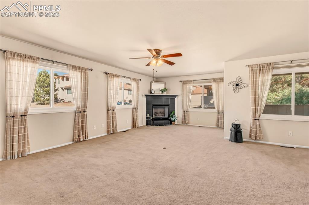 Bright living room featuring a cozy gas fireplace and an abundance of windows for natural lighting. 
