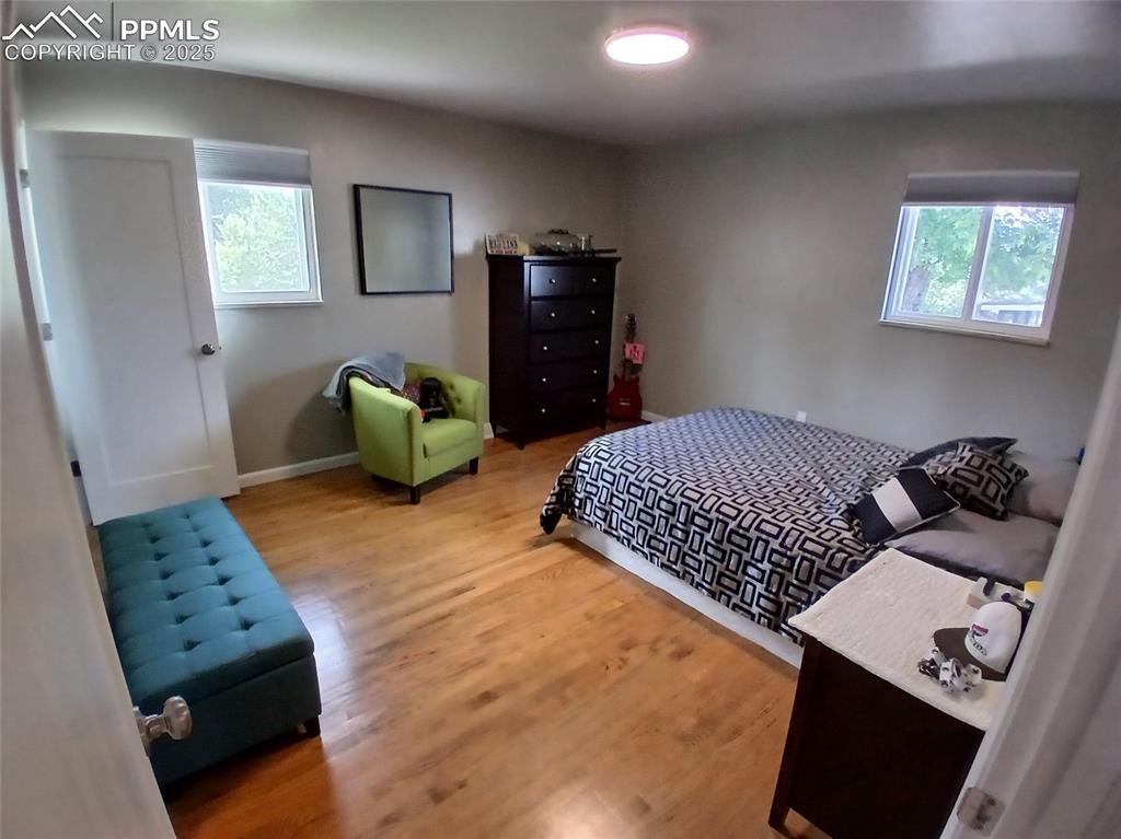 Bedroom with hardwood / wood-style flooring and multiple windows