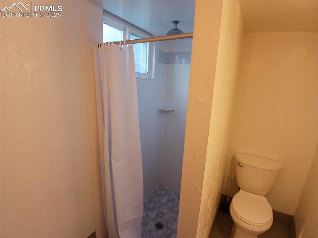 Basement bathroom featuring a stand up shower.