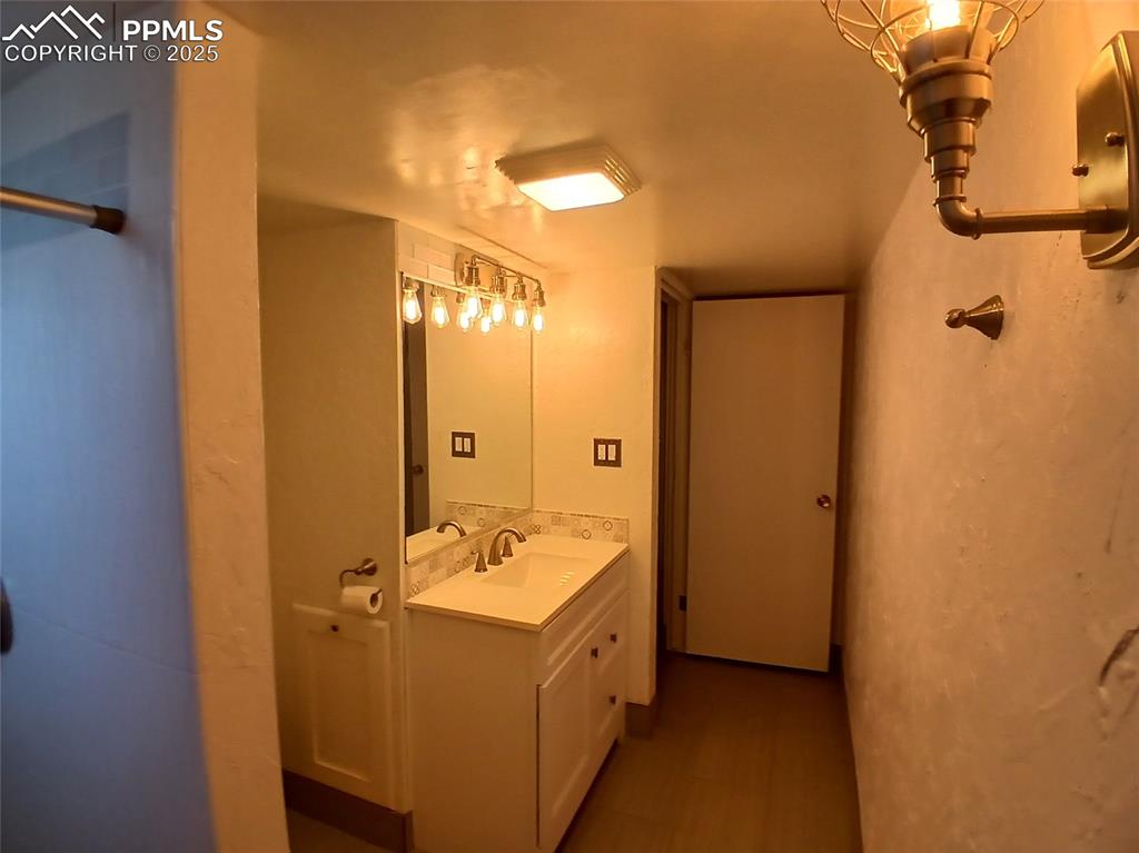 Basement 3/4 bathroom featuring tile floors and large vanity