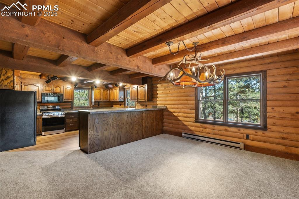 View from dining room to kitchen, New carpet and LVT. New gas range. All cabinets have been sanded and freshly sealed. Custom antler chandelier