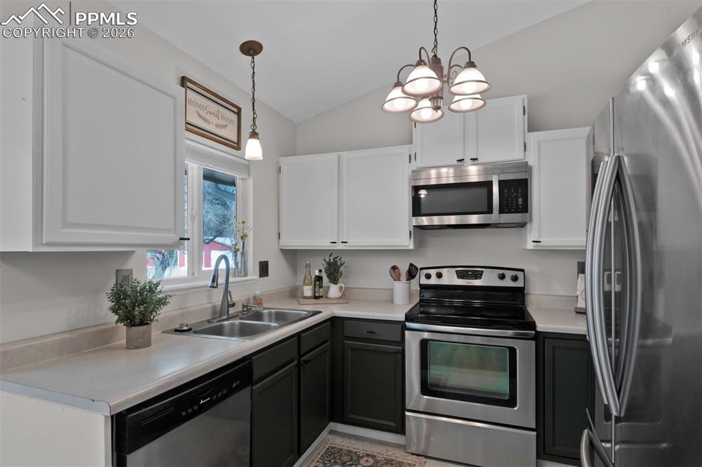 Modern white and green painted cabinetry and stainless appliances. 
