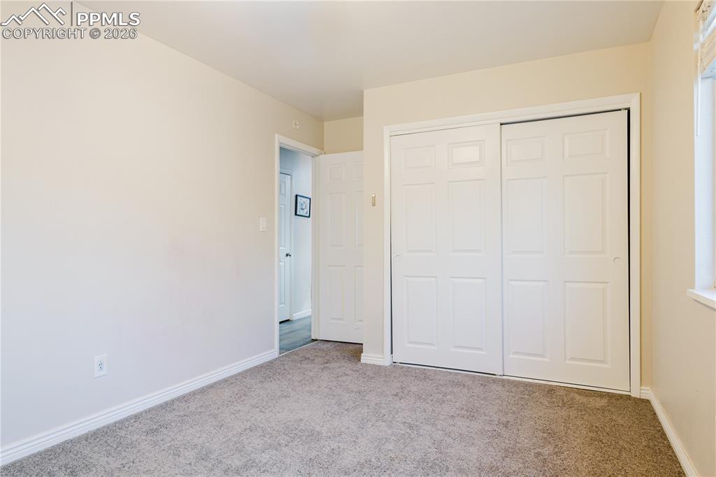 Unfurnished bedroom featuring carpet and a closet
