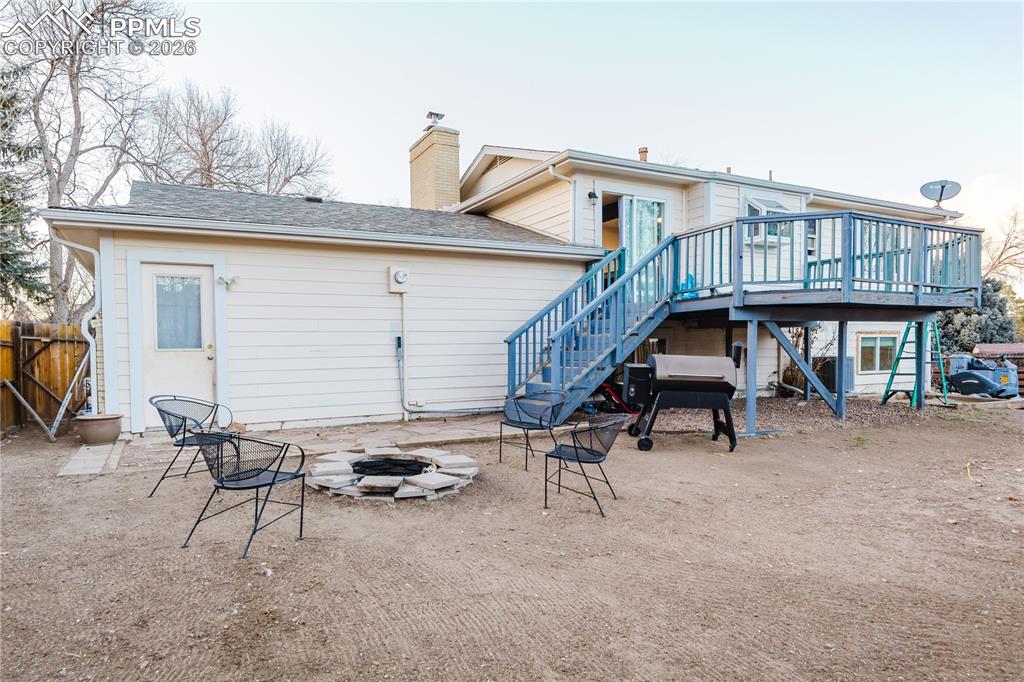 Back of house with an outdoor fire pit, a patio area, a chimney, and a wooden deck