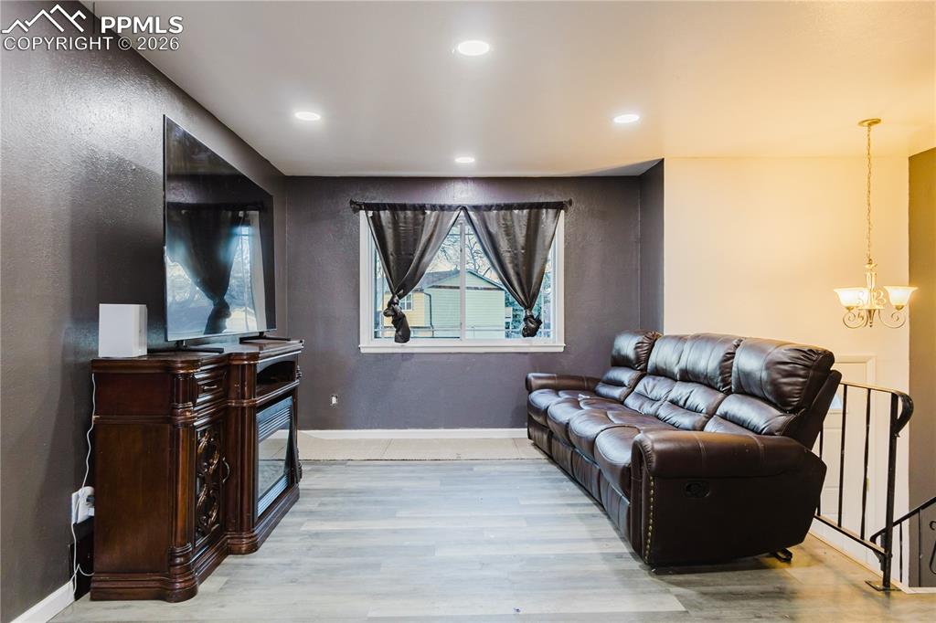 Living room with light wood finished floors and a chandelier
