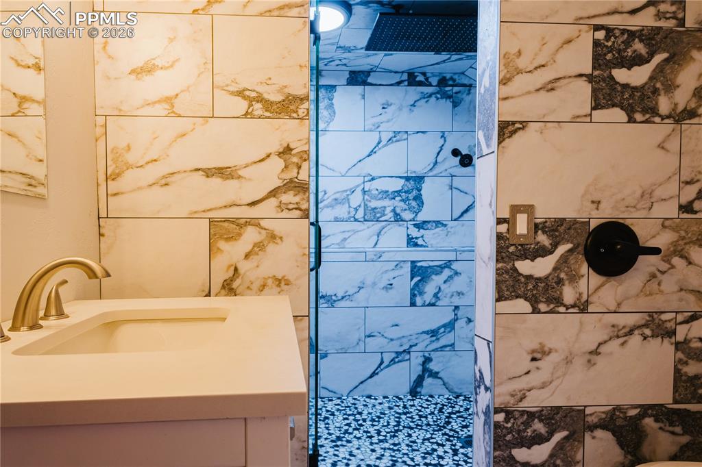 Full bath with a tile shower and vanity