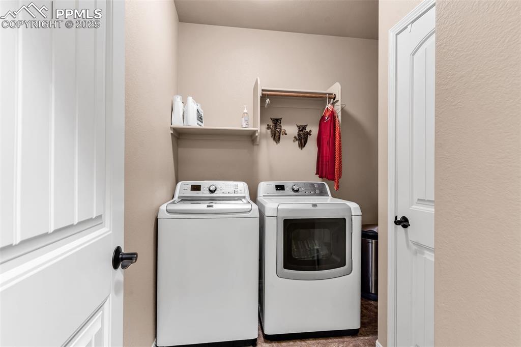 The laundry is open and spacious with built in shelving and a hanging rod.