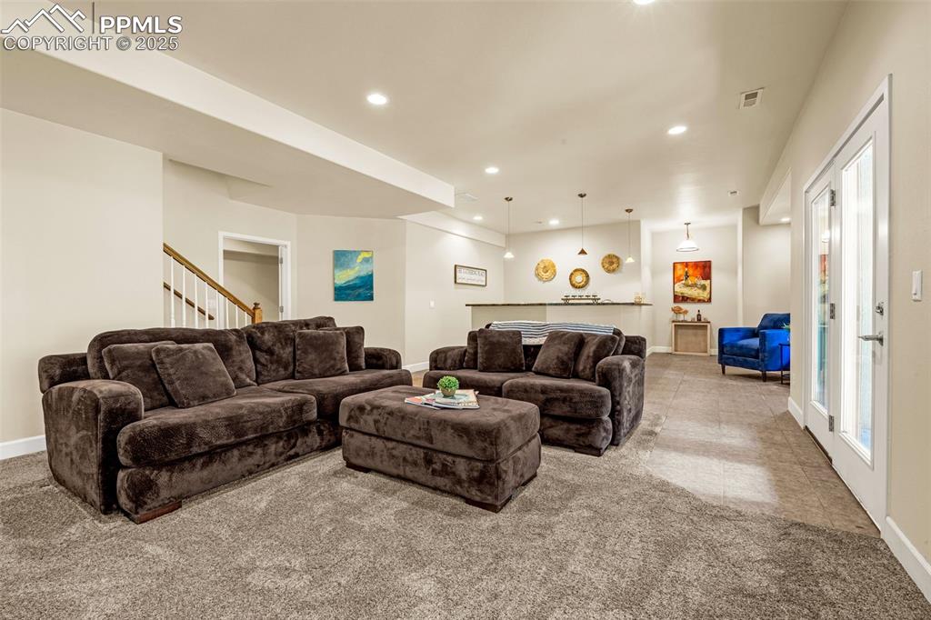 Living room featuring baseboards, recessed lighting, carpet flooring, and stairway
