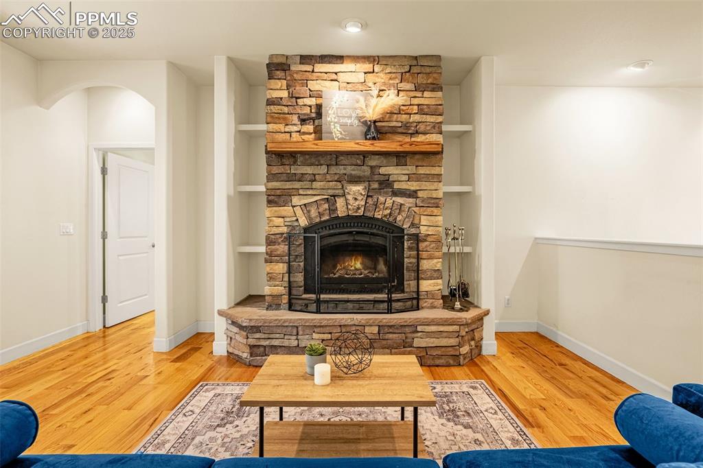 Living area featuring a fireplace, wood finished floors, and baseboards