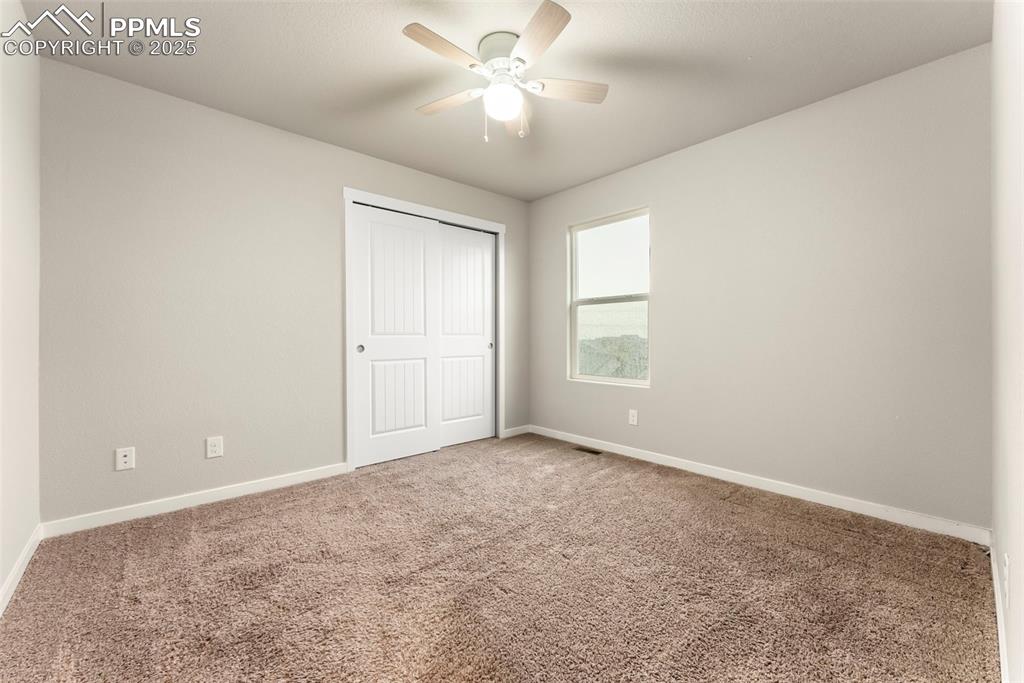 Unfurnished bedroom with carpet flooring, a closet, and ceiling fan