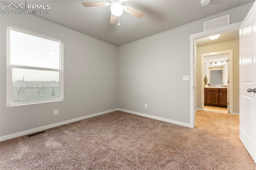 Spare room with light colored carpet and a ceiling fan