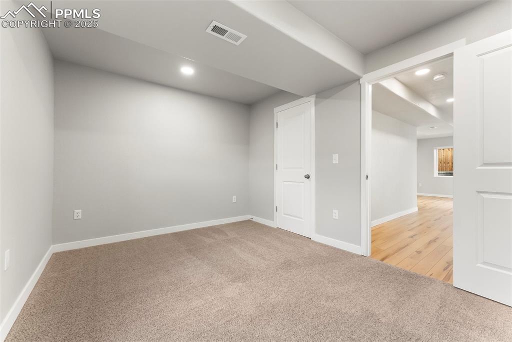 Basement with light carpet and recessed lighting