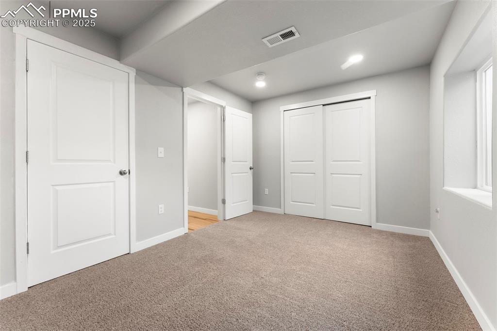 Unfurnished bedroom featuring light carpet and recessed lighting