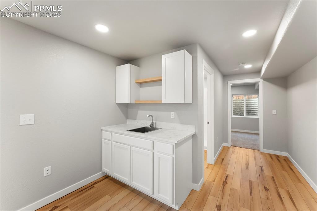 Kitchen with white cabinetry, open shelves, light wood-type flooring, and recessed lighting