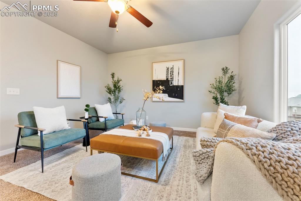 Sitting room featuring carpet flooring, ceiling fan, and plenty of natural light