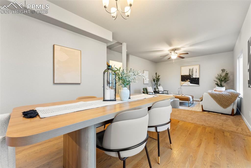 Dining space featuring light wood-style flooring, a chandelier, and a ceiling fan