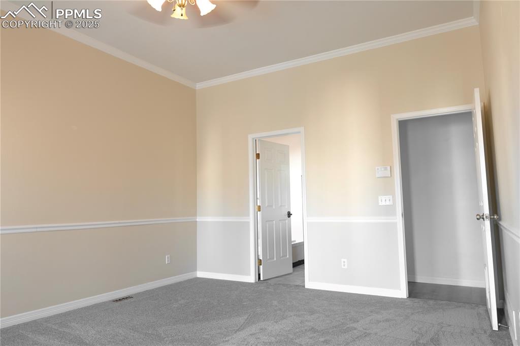 Unfurnished bedroom with carpet flooring, ornamental molding, and a ceiling fan