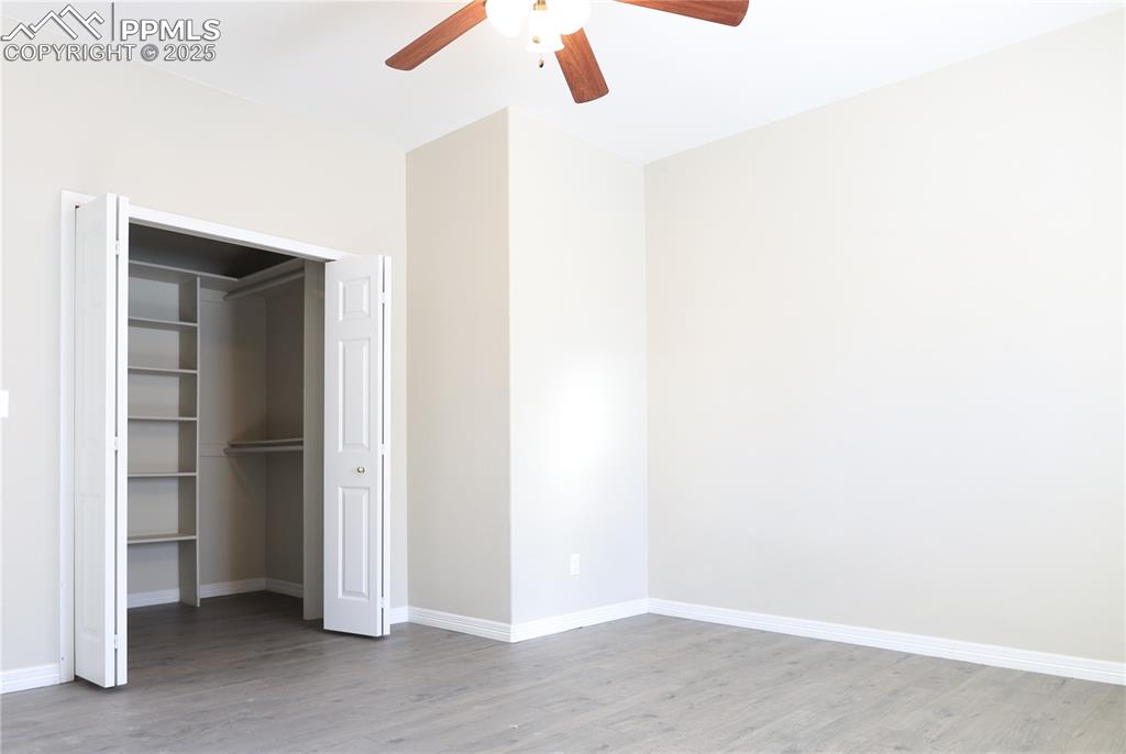 Unfurnished bedroom with light wood-style flooring, a closet, and ceiling fan