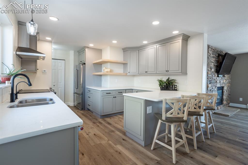 Kitchen featuring floating wrapped shelves, recessed lighting. 