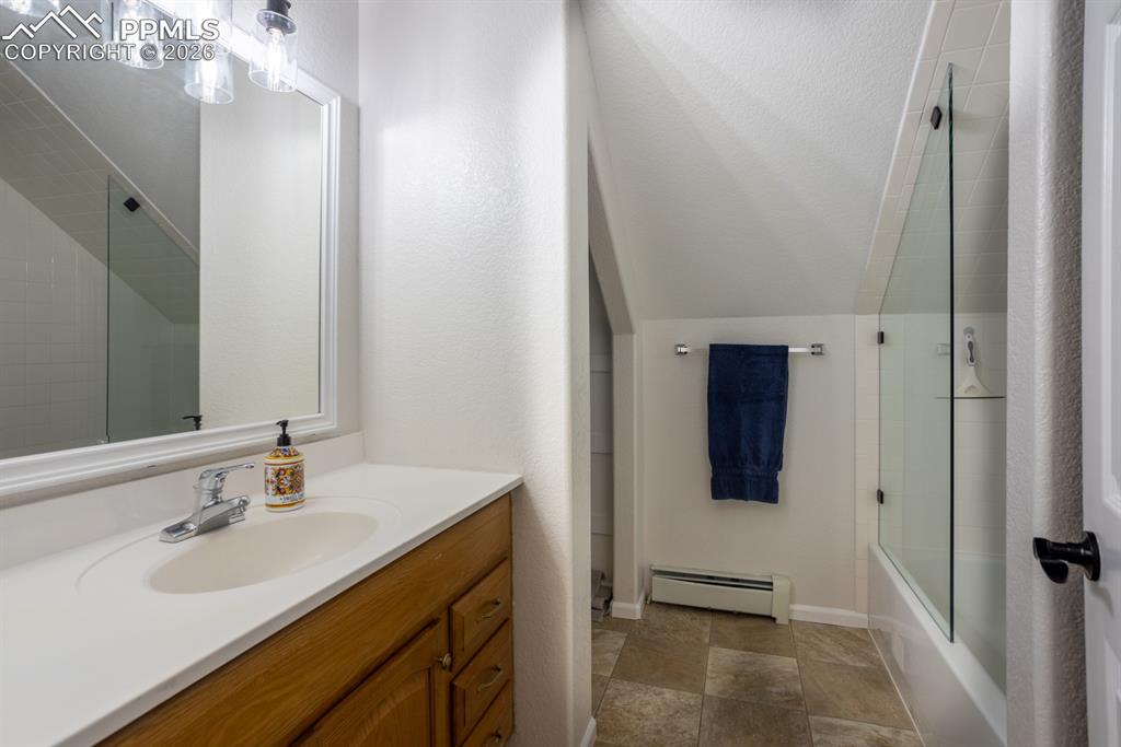 Upper level full Bathroom featuring custom glass shower door. 