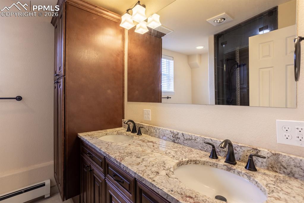 Basement bathroom with walk in steam shower, custom cabinets, granite, and double vanity.
