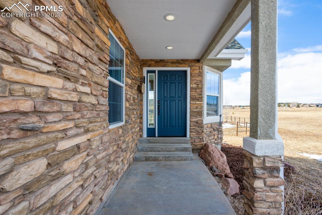 Doorway to property with stone siding