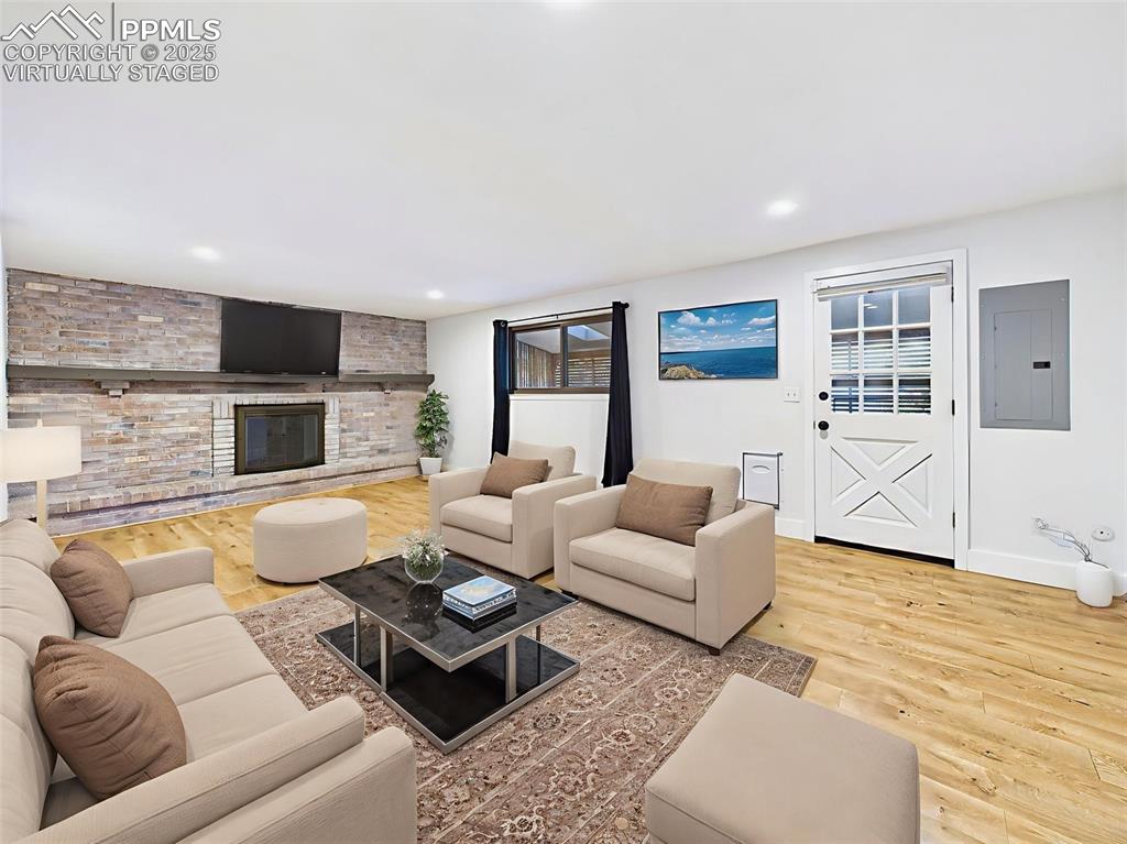 Virtually staged to showcase a cozy second living area, this space features a full-length brick fireplace wall and walk-out access to the backyard.